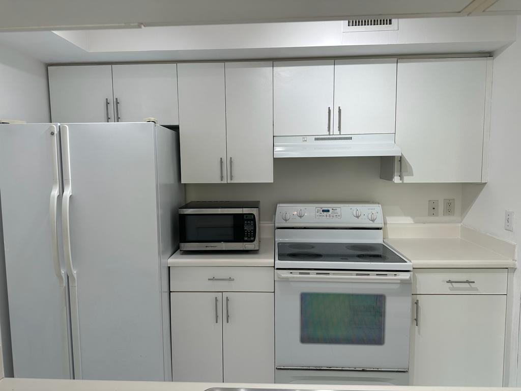 4844 North State Road 7, Unit 305 Pompano Beach, FL 33067 - Photo 19 of 23 a kitchen with cabinets and steel stainless steel appliances