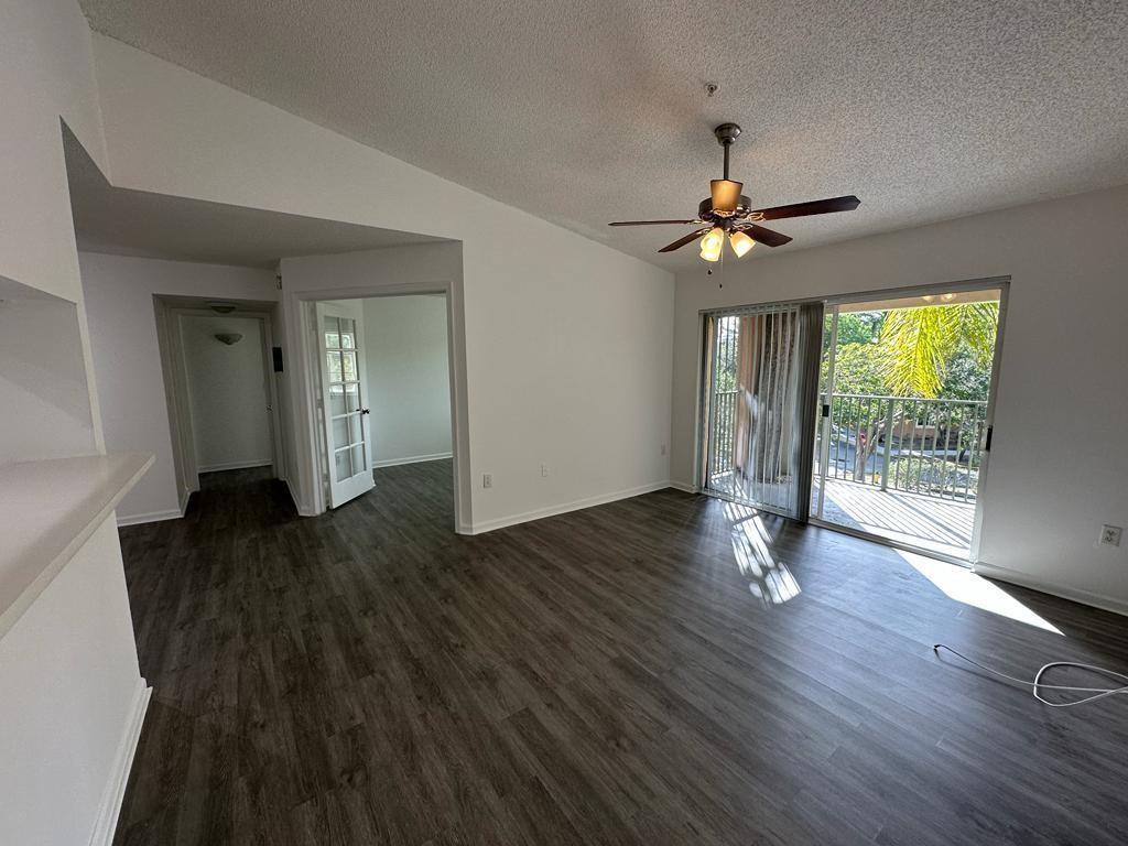 4844 North State Road 7, Unit 305 Pompano Beach, FL 33067 - Photo 23 of 23 a view of an empty room with wooden floor and a window
