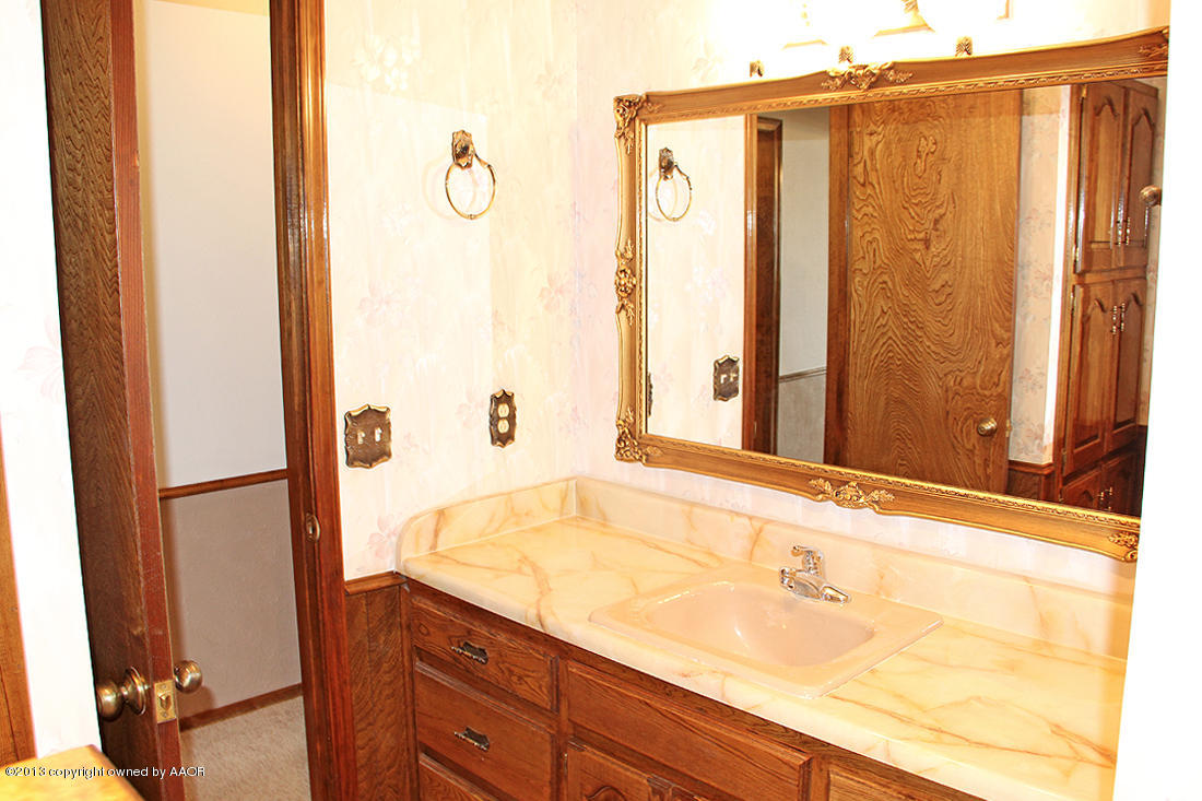 7103 Hatton Road Amarillo, TX 79110 - Photo 14 of 28 a bathroom with a granite countertop sink and a mirror