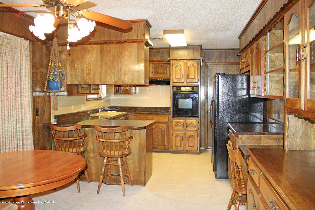 7103 Hatton Road Amarillo, TX 79110 - Photo 2 of 28 a kitchen with stainless steel appliances kitchen island granite countertop a refrigerator a stove and a sink with granite countertops