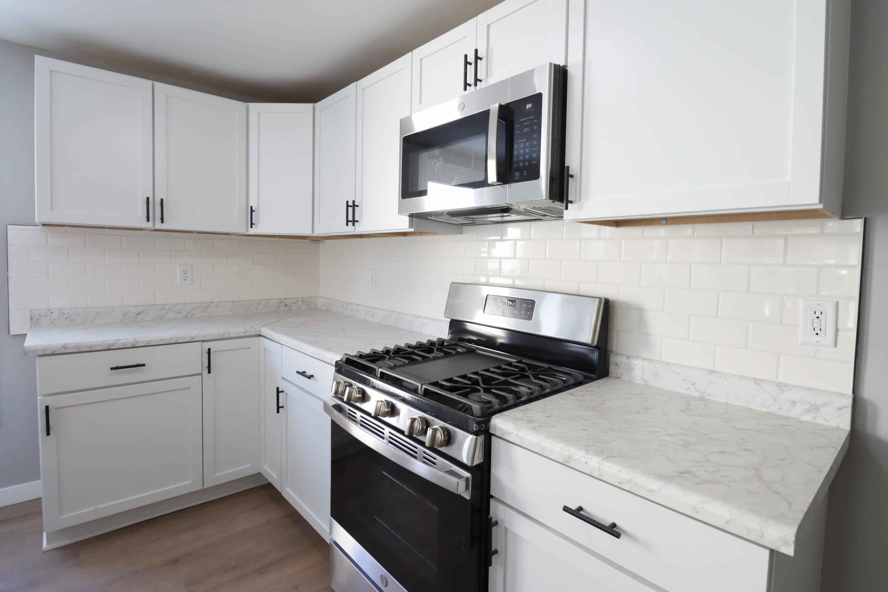 117 Patton Street La Porte, IN 46350 - Photo 12 of 45 a kitchen with stainless steel appliances granite countertop white cabinets a sink and dishwasher