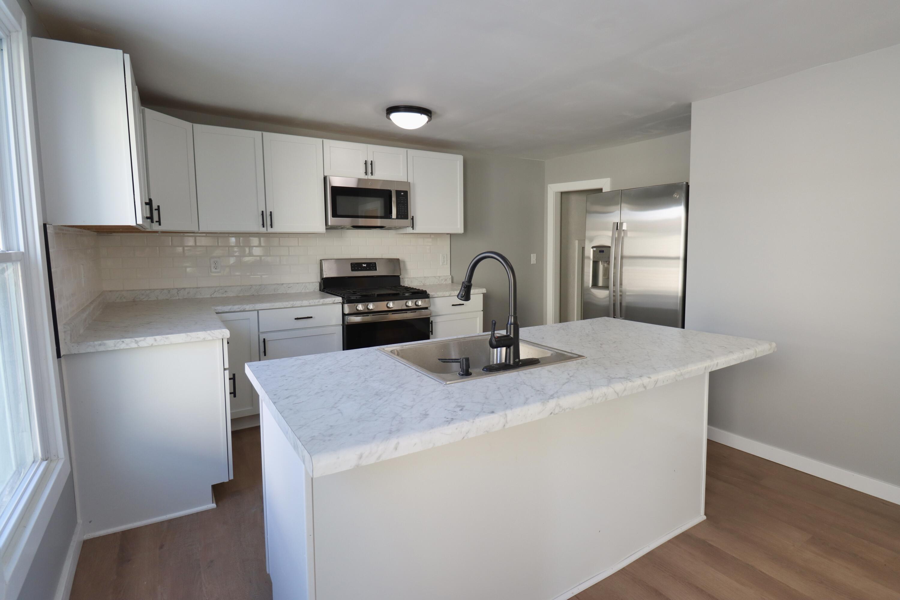117 Patton Street La Porte, IN 46350 - Photo 13 of 45 a kitchen with stainless steel appliances granite countertop a sink a stove a refrigerator a microwave a sink and cabinets