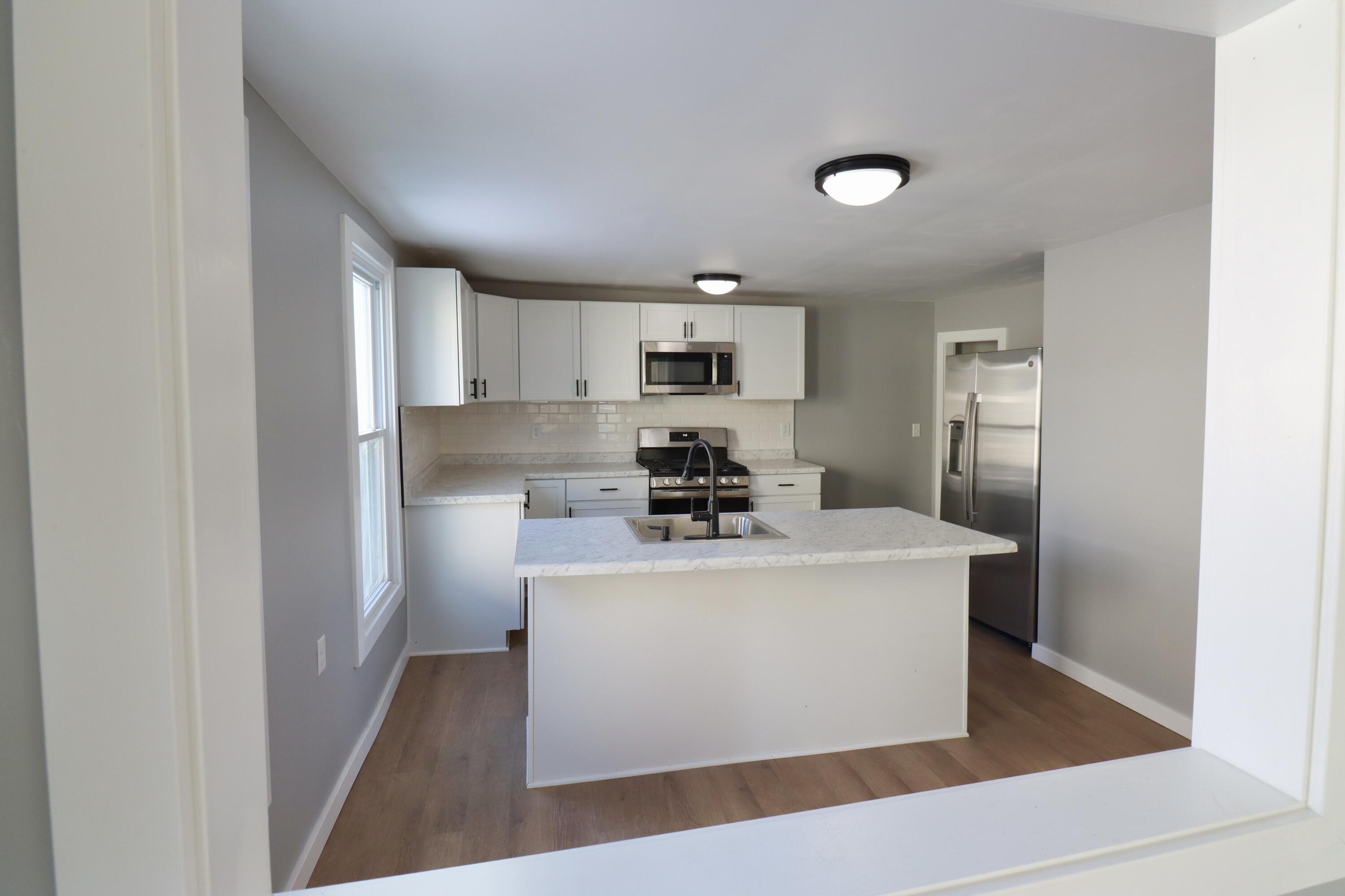 117 Patton Street La Porte, IN 46350 - Photo 9 of 45 a kitchen with a sink a refrigerator and cabinets