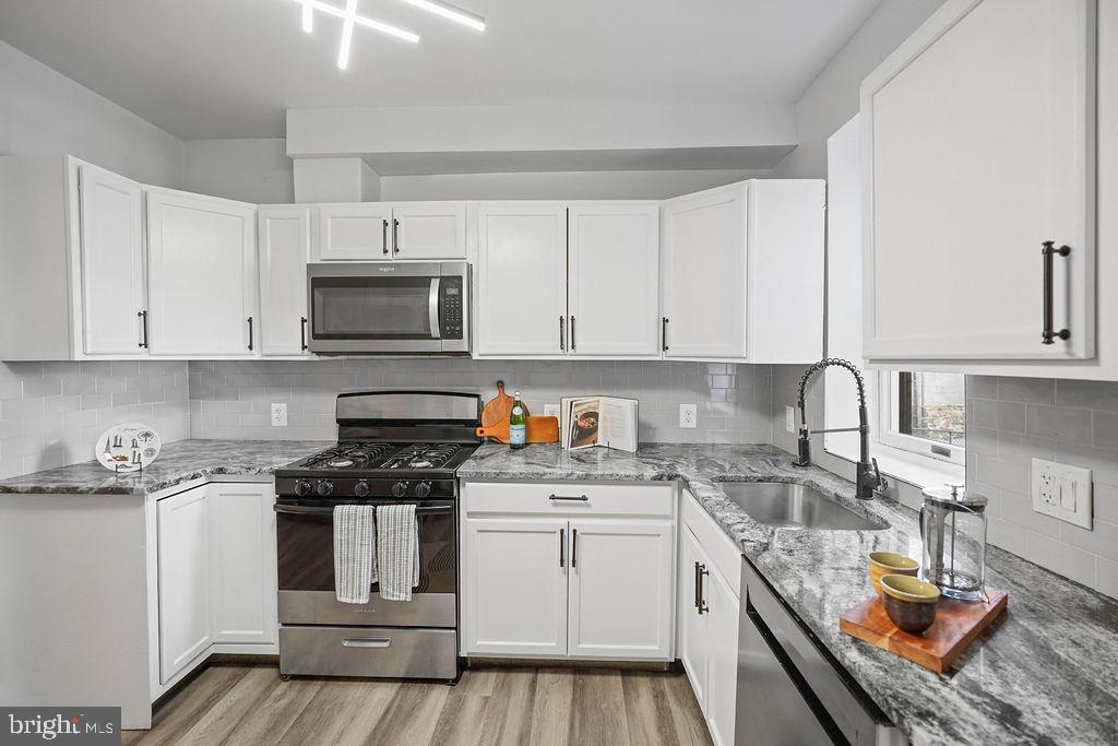 1337 Ward Street Baltimore, MD 21230 - Photo 4 of 17 a kitchen with granite countertop a sink a stove and cabinets
