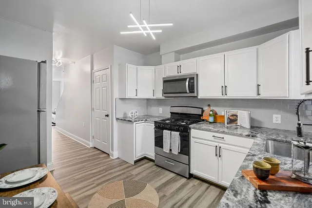 a kitchen with stainless steel appliances a white cabinets stove top oven and sink