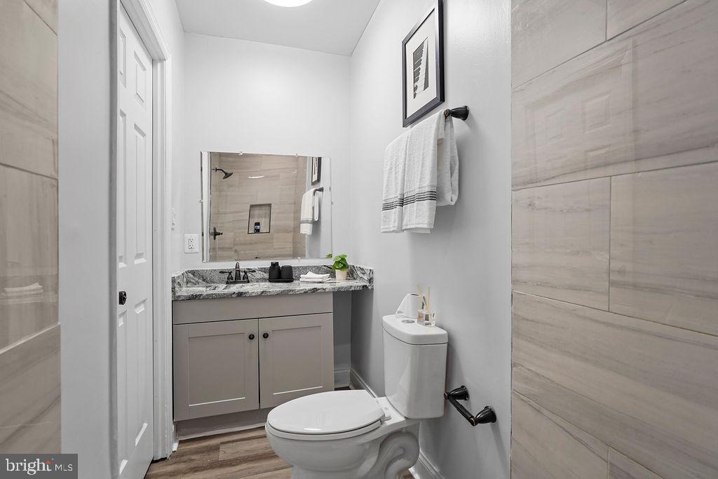 1337 Ward Street Baltimore, MD 21230 - Photo 10 of 17 a bathroom with a granite countertop toilet a sink and a mirror