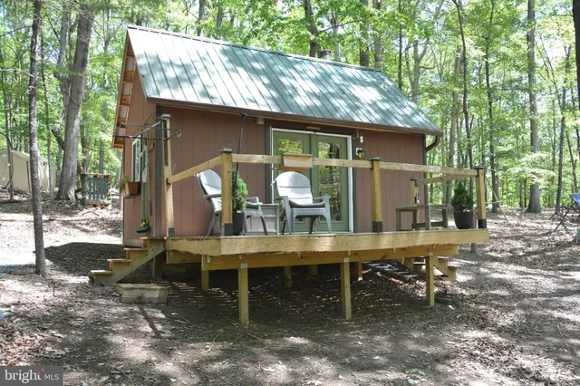 a view of a wooden chairs and table in the patio
