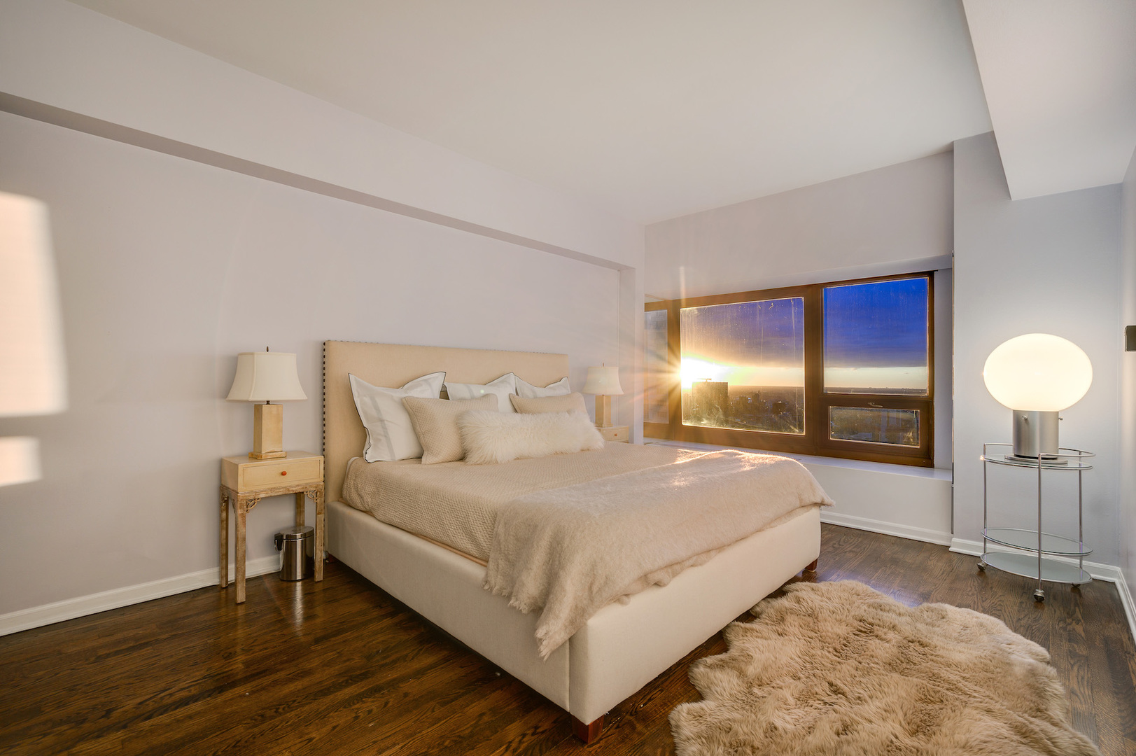 175 East Delaware Place, Unit 46254601 Chicago, IL 60611 - Photo 23 of 33 a spacious bedroom with a bed and a lamp on table