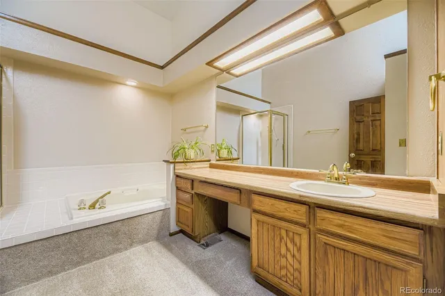 a spacious bathroom with a granite countertop sink and a bathtub
