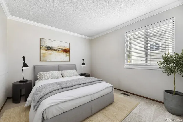 a bedroom with a bed and a potted plant