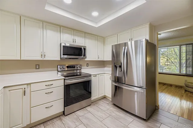 a kitchen with white cabinets and stainless steel appliances