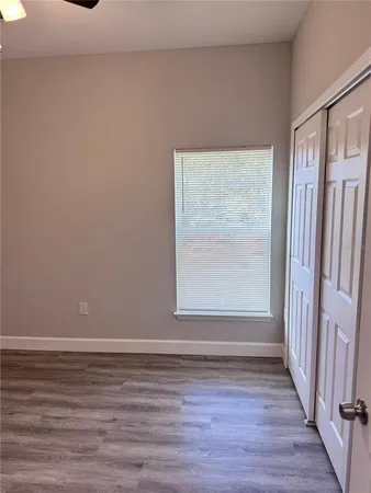 a view of a small space with wooden floor and a window