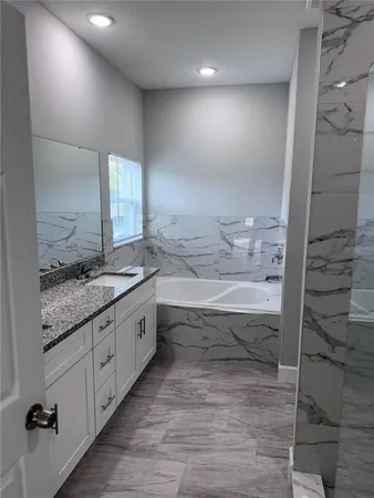 a bathroom with a granite countertop sink and a mirror