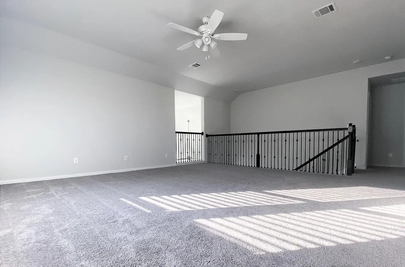 717 Paper Daisy Path Leander, TX 78641 - Photo 5 of 7 A spacious upper-level area offers versatile living space with plush carpeting and a classic ceiling fan.