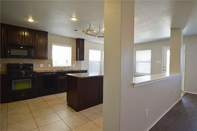 a kitchen with stainless steel appliances granite countertop a refrigerator and a stove top oven