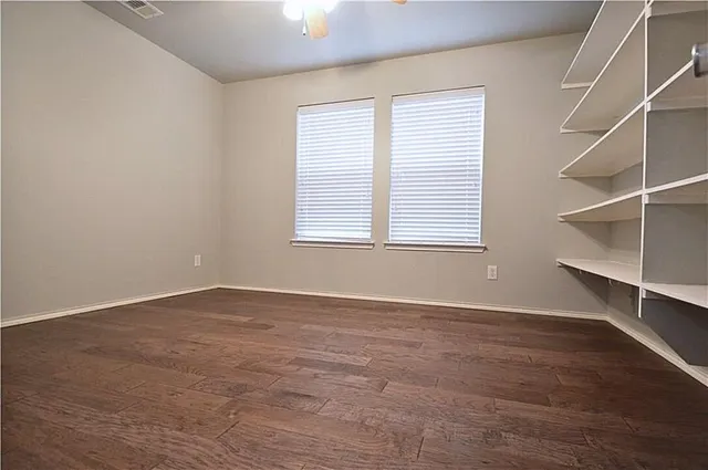 an empty room with wooden floor and window