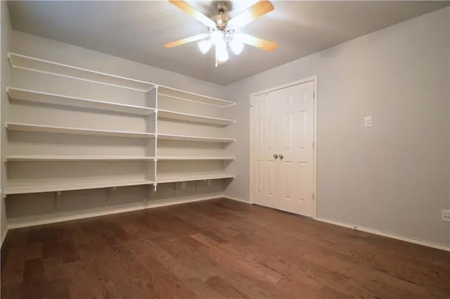 a view of room with a ceiling fan and wooden floor