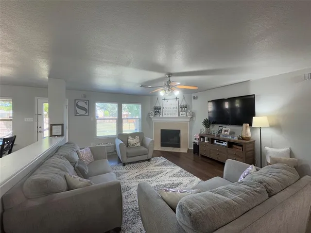 a living room with furniture a flat screen tv and a fireplace