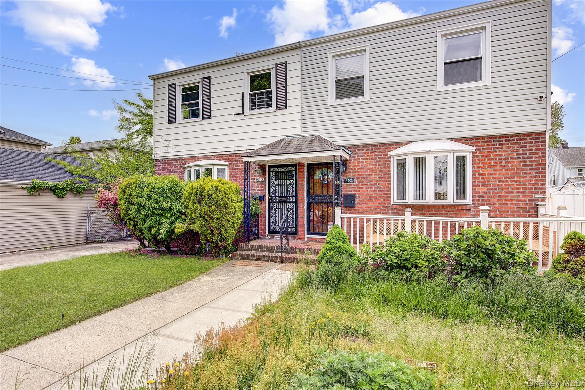 a front view of a house with a yard and potted plants
