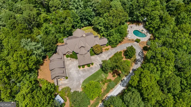 an aerial view of a house with yard and greenery