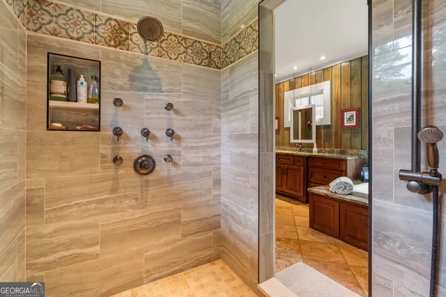 a bathroom with a toilet a sink a mirror and a shower