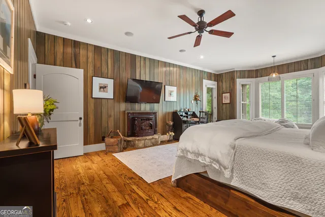 a spacious bedroom with a bed a mirror and a table in it