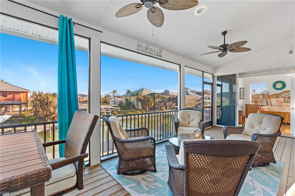 256 Curlew Street Fort Myers Beach, FL 33931 - Photo 14 of 43 Sunroom / solarium featuring lofted ceiling and ceiling fan. virtually enhanced photo