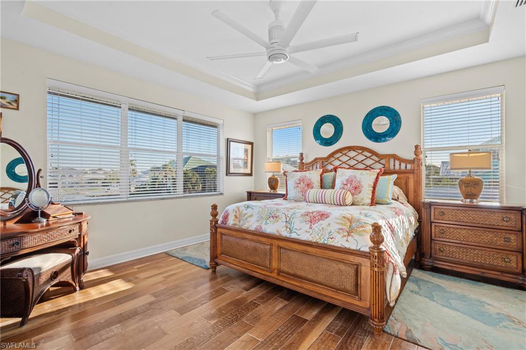 256 Curlew Street Fort Myers Beach, FL 33931 - Photo 17 of 43 Bedroom with multiple windows, crown molding, a raised ceiling, and ceiling fan. virtually enhanced photo