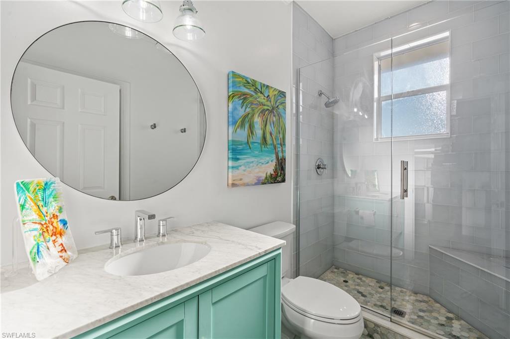 256 Curlew Street Fort Myers Beach, FL 33931 - Photo 24 of 43 Bathroom featuring vanity, toilet, and walk in shower. virtually enhanced photo