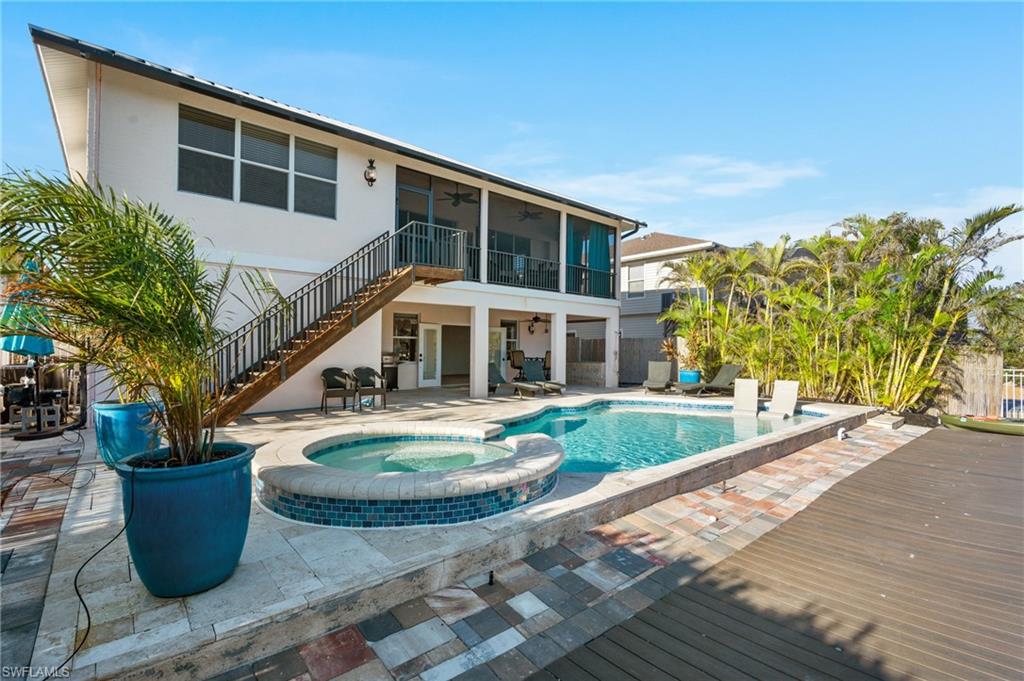 256 Curlew Street Fort Myers Beach, FL 33931 - Photo 5 of 43 View of pool with a sunroom, a patio, ceiling fan, and an in ground hot tub. virtually enhanced photo