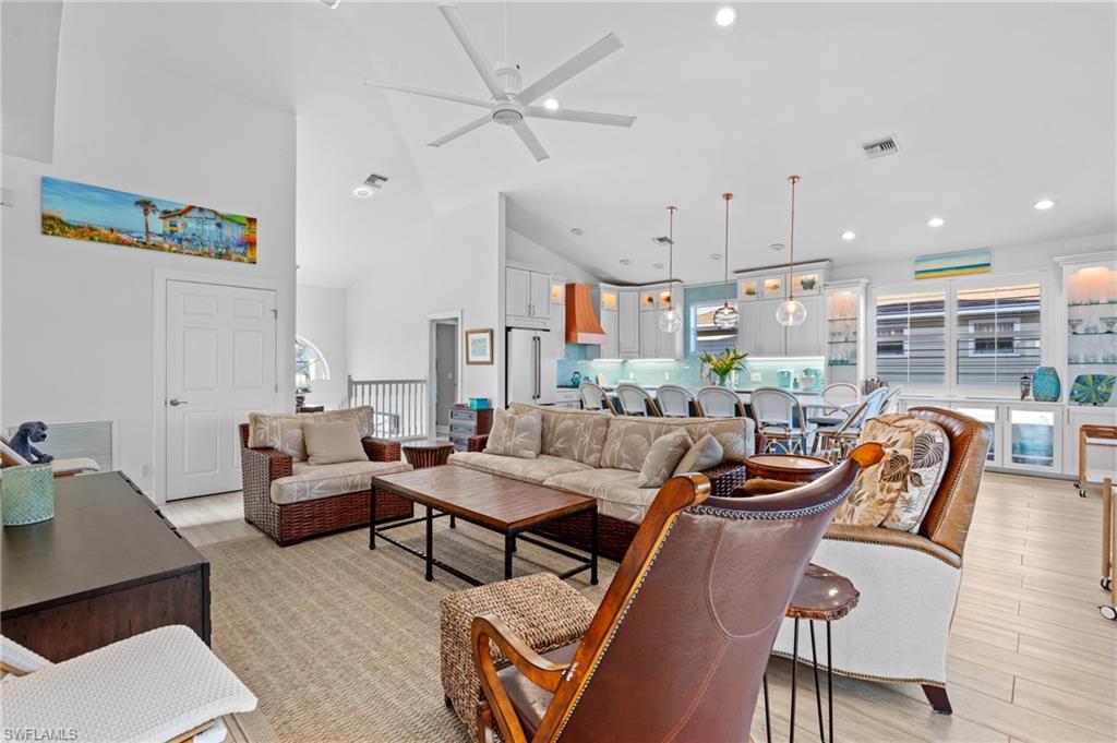 256 Curlew Street Fort Myers Beach, FL 33931 - Photo 10 of 43 Living room with ceiling fan, high vaulted ceiling, and light wood-type flooring. virtually enhanced photo