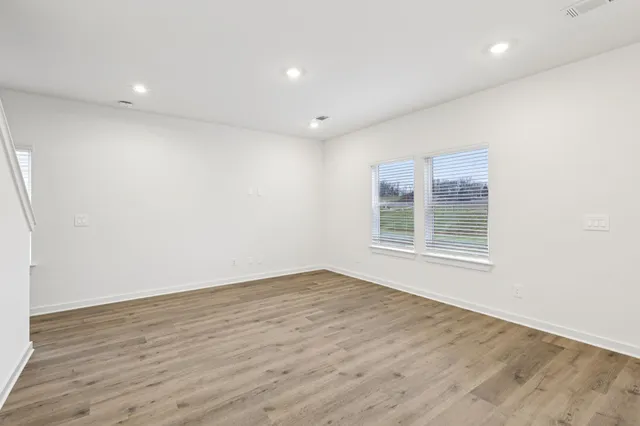 a view of kitchen with kitchen island wooden floors and stainless steel appliances