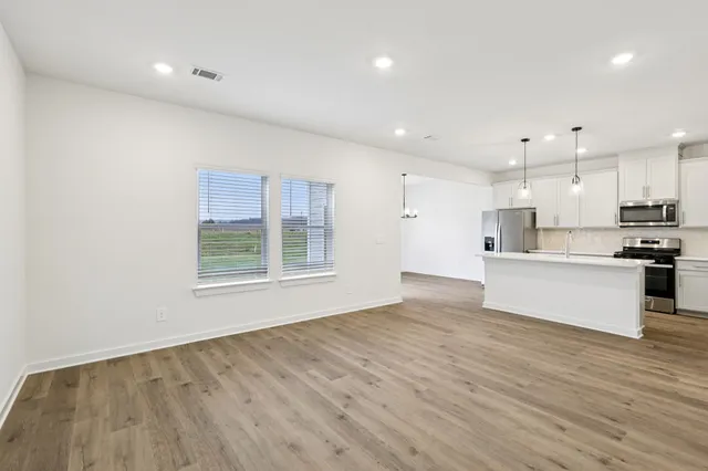 a view of kitchen with kitchen island a sink a center island stainless steel appliances and a window