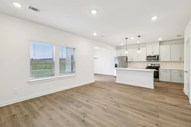a large white kitchen with stainless steel appliances