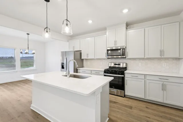 a view of a kitchen with a sink hardwood floor and a ceiling fan