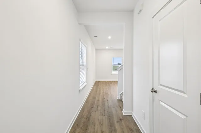 a view of a hallway with wooden floor