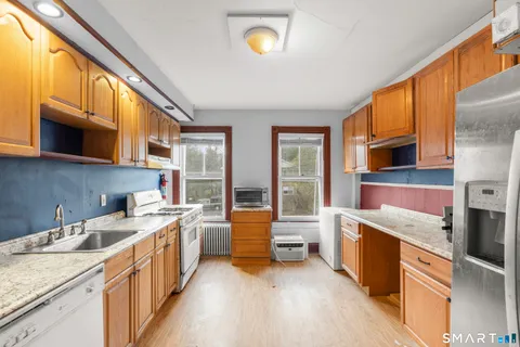 a kitchen that has a lot of cabinets in it and wooden floors