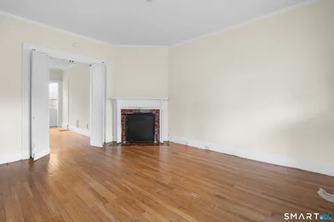 a view of empty room with wooden floor and fireplace