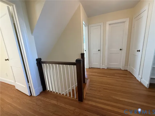 a view of a hallway with wooden floor and staircase