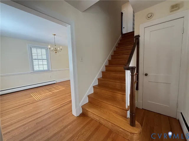 a view of an entryway with wooden floor and staircase