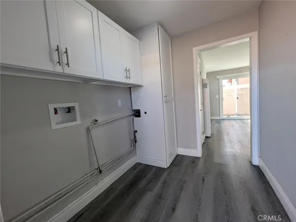 a view of a kitchen with wooden floor and cabinets