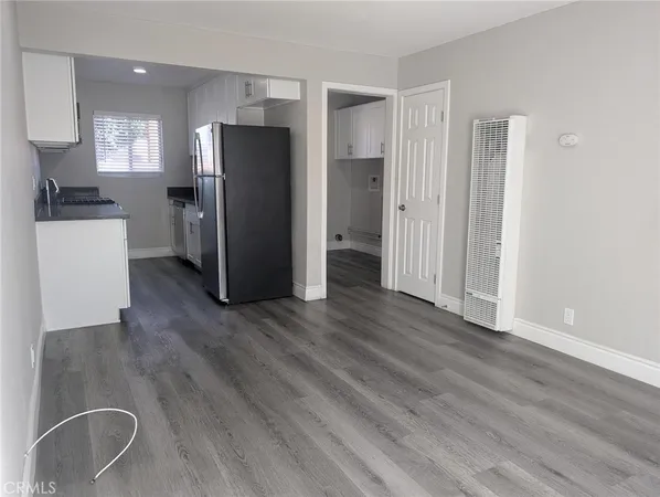 a kitchen with stainless steel appliances a refrigerator and wooden floor