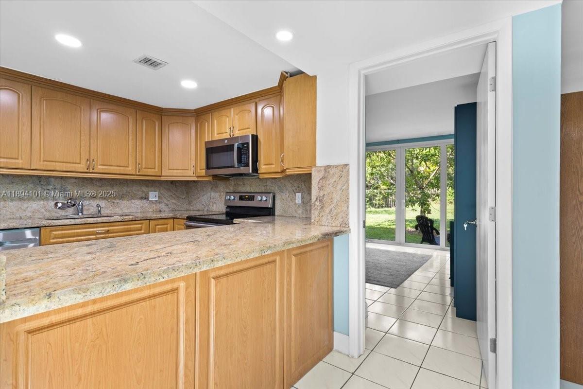 9450 Live Oak Place, Unit 109 Davie, FL 33324 - Photo 19 of 98 a kitchen with stainless steel appliances granite countertop a stove a sink and a microwave