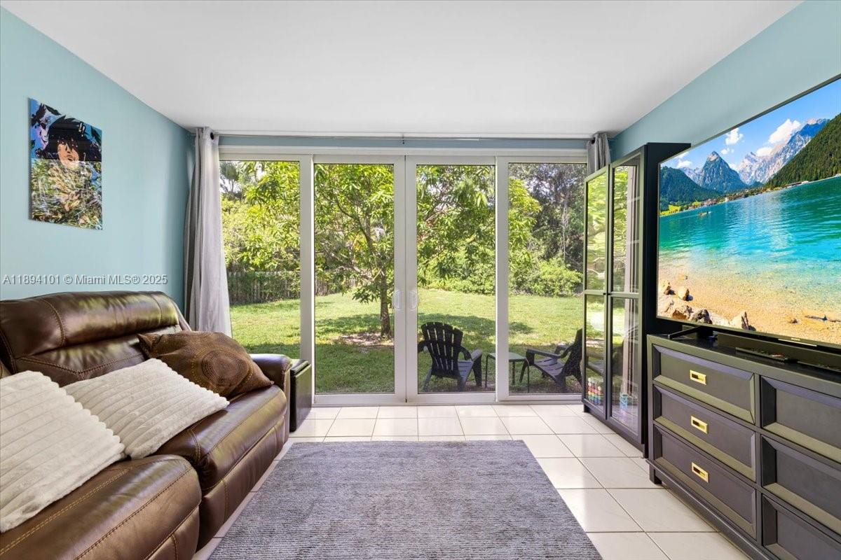 9450 Live Oak Place, Unit 109 Davie, FL 33324 - Photo 22 of 98 a living room with furniture and floor to ceiling windows