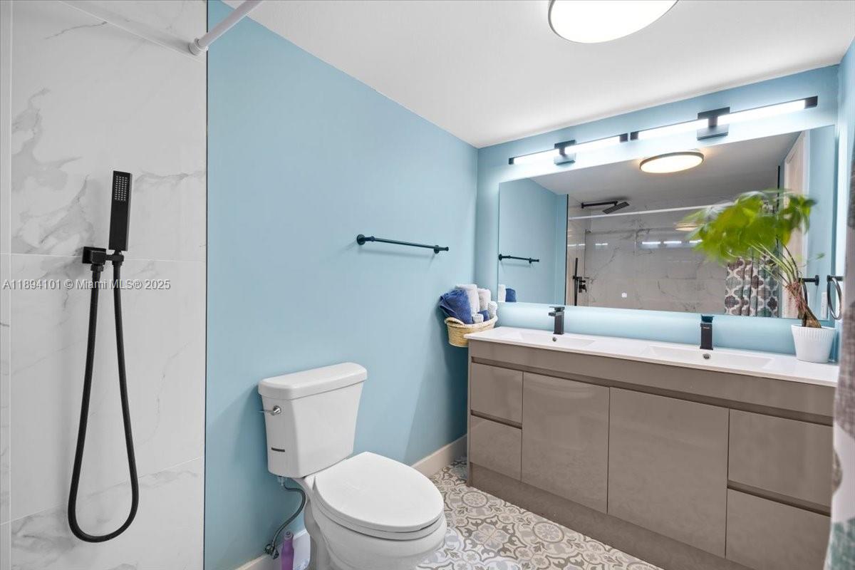 9450 Live Oak Place, Unit 109 Davie, FL 33324 - Photo 33 of 98 a bathroom with a toilet sink and mirror