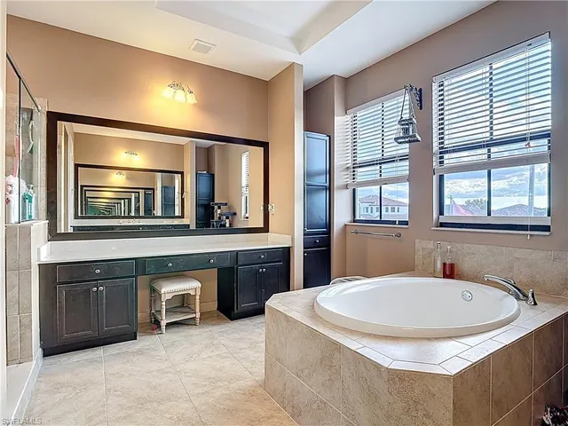 a bathroom with a tub sink and mirror