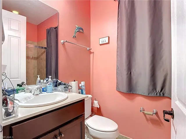 a bathroom with a sink vanity mirror and toilet
