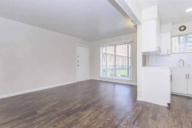 a view of a kitchen with wooden floor and a window