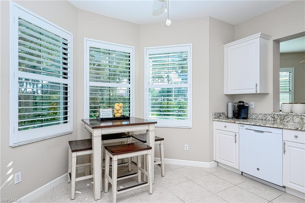 2371 Ravenna Boulevard, Unit 101 Naples, FL 34109 - Photo 11 of 44 Kitchen featuring dishwasher, light stone counters, white cabinetry, light tile patterned floors, and ceiling fan