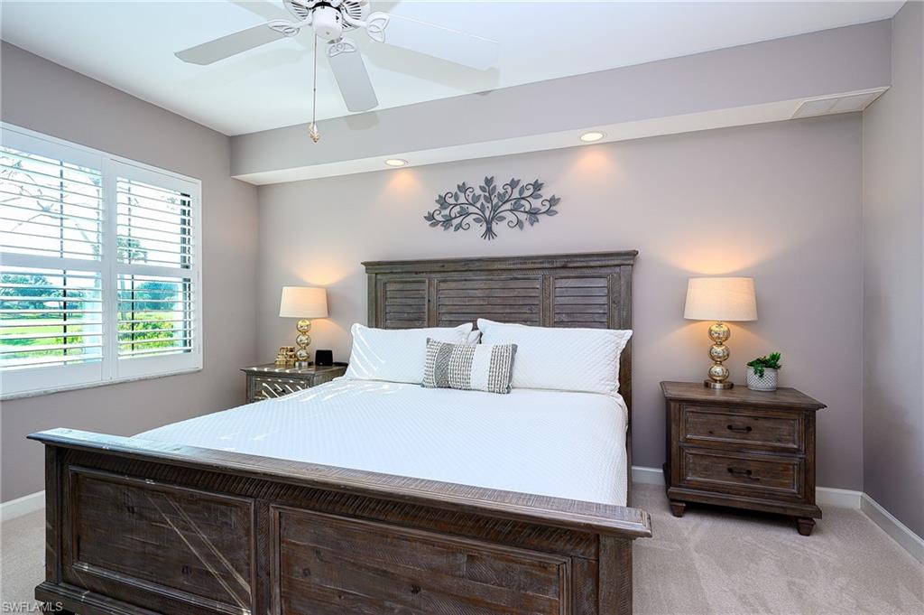 2371 Ravenna Boulevard, Unit 101 Naples, FL 34109 - Photo 12 of 44 Carpeted bedroom with ceiling fan
